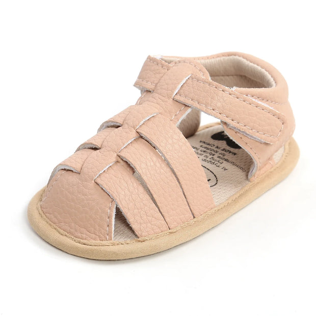 Beige baby sandal with multiple straps on a white background