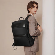 Man in a suit with a black backpack against a beige background