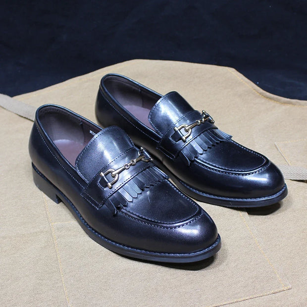 Pair of shiny blue loafers with gold accents on a beige surface.