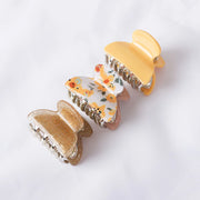 Two butterfly-shaped hair clips on a white background