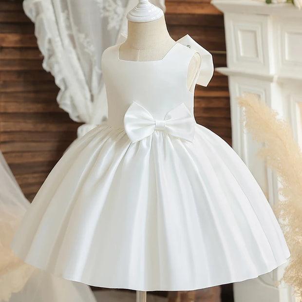 White dress with a large bow on a mannequin against a decorative background