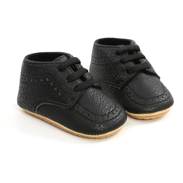 Pair of black baby shoes with laces on a white background