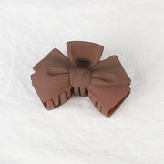 Brown bow-shaped object on a white textured background