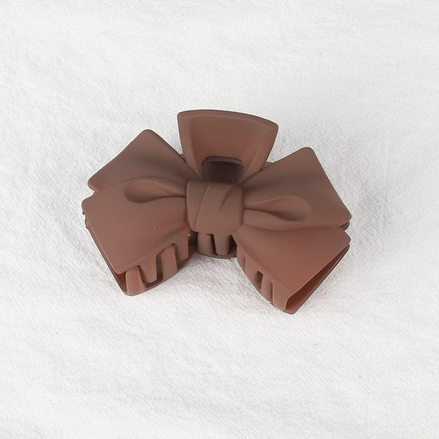Brown bow-shaped object on a white textured background