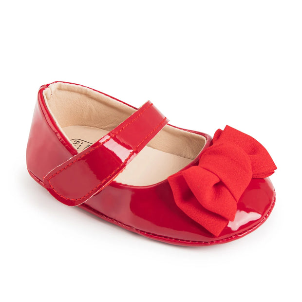 Red baby shoe with a bow on a white background