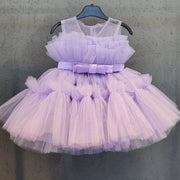 Lavender tulle dress with a bow on a hanger against a gray background