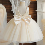 White dress with a large bow on a mannequin against a neutral background