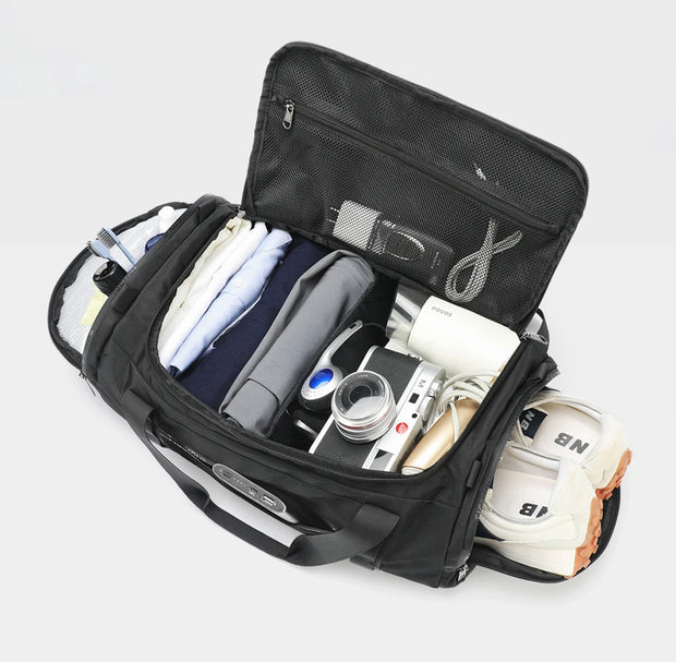 Open black travel bag with various items on a light gray background