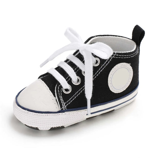 Black and white baby shoe with a white sole on a white background