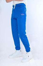 Blue tracksuit pants with white text on a white background
