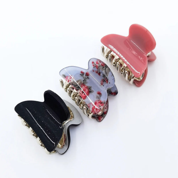 Set of four floral-themed hair clips on a white background