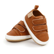 Pair of brown children's shoes with white soles on a white background