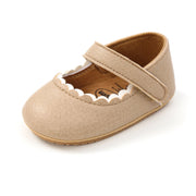 Beige baby shoe with a strap on a white background