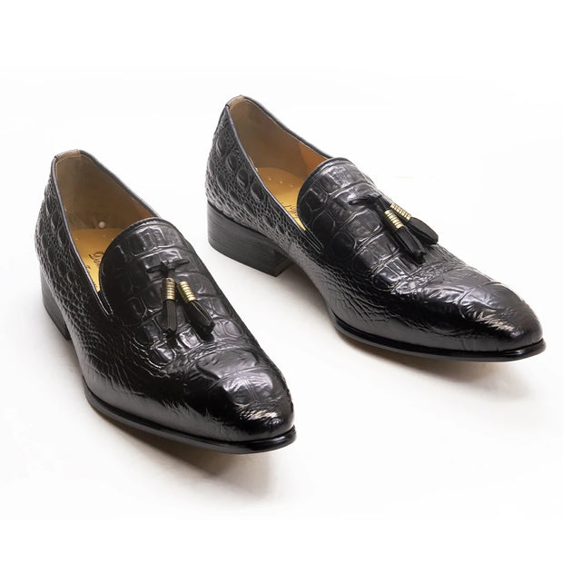 Pair of black crocodile skin loafers with tassels on a white background