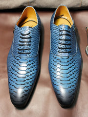 Blue textured dress shoes on a brown surface