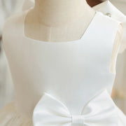 White dress with a bow detail on a mannequin against a neutral background