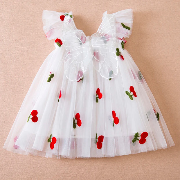 White dress with red cherry designs on a beige background