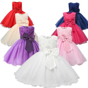 Set of colorful children's dresses with large bows on a white background