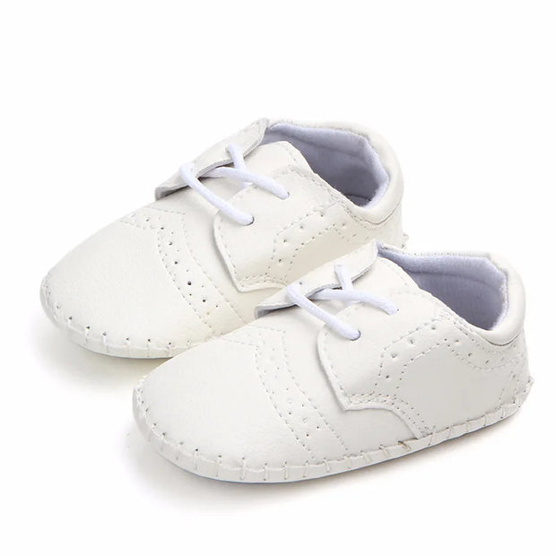 White baby shoes with lace-up design on a white background