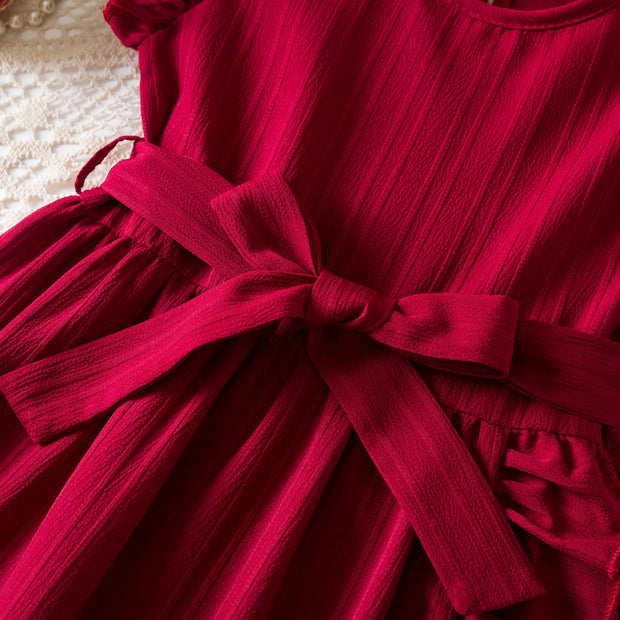 Red dress with a bow detail on a textured surface