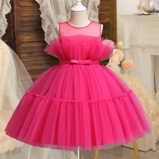 Pink tulle dress on a mannequin against a decorative background
