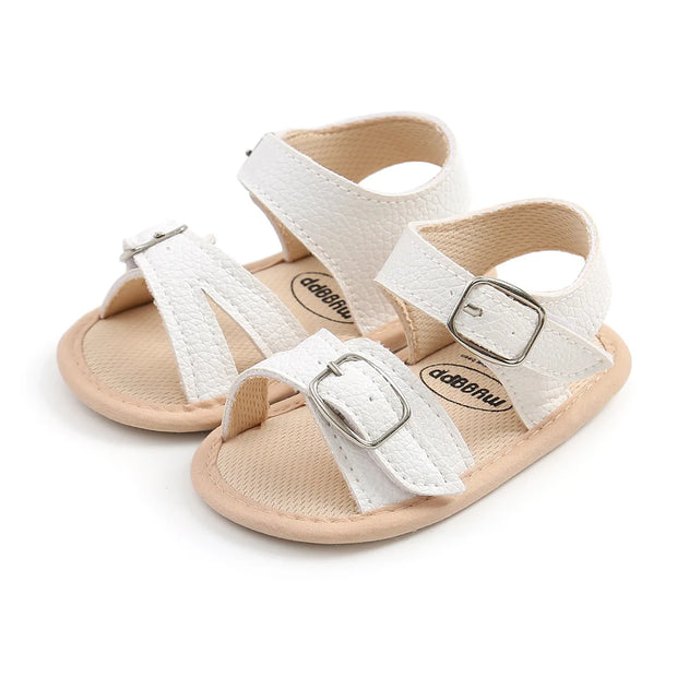 Pair of white sandals with beige soles on a white background