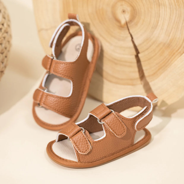 Pair of brown children's sandals on a light background