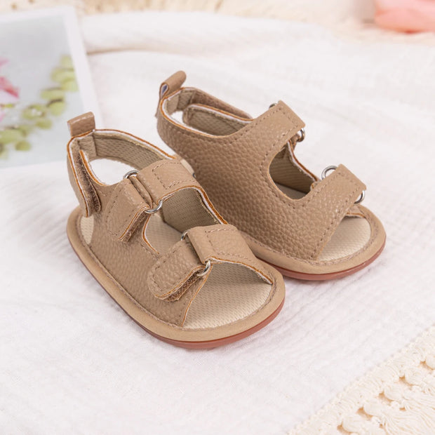 Pair of beige baby sandals on a soft white background