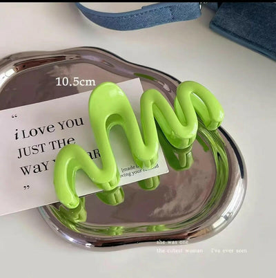 Green spiral-shaped object on a clear stand with text underneath