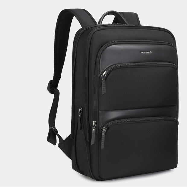 Black backpack with multiple zippers on a light gray background
