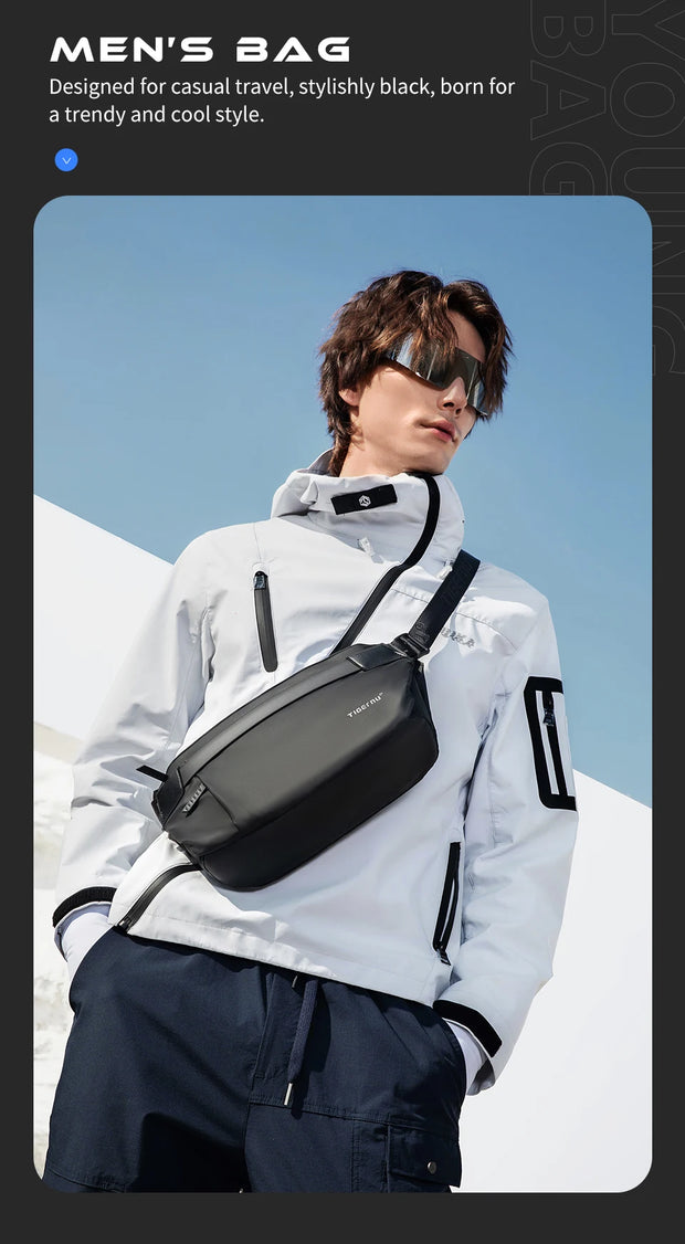 Man wearing a black men's bag against a clear blue sky