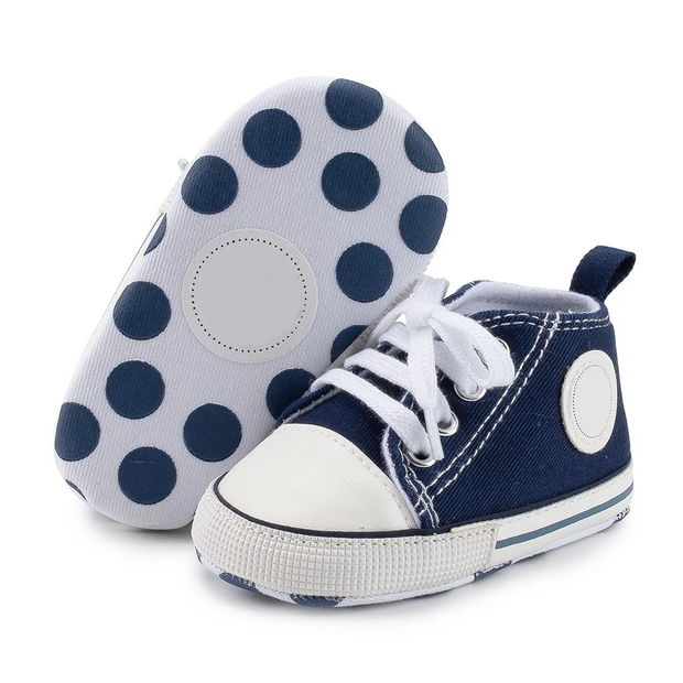 Navy blue and white baby shoes with polka dot design on a white background