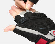 Black and gray glove with red accents being adjusted on a white background